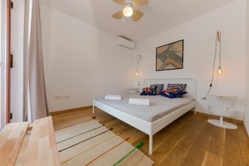 a white bedroom with a bed and a ceiling at Casa Dubi Hvar in Hvar