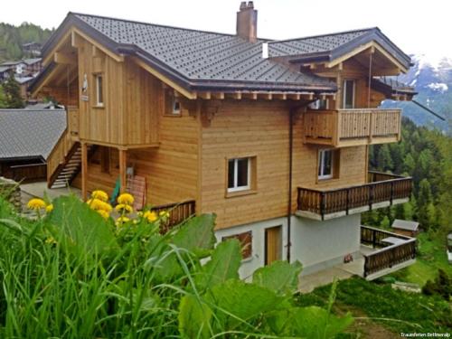 a large wooden house with a balcony on a hill at am Bärgbach DG in Bettmeralp
