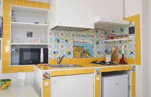 una cocina con fregadero y microondas en LA SCALINATELLA -vista mare-, en Vietri
