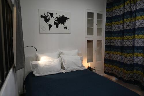 a bedroom with a bed with white pillows and a map on the wall at la terrasse in Nice