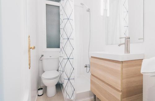 a white bathroom with a toilet and a sink at Altair apartment by People Rentals in Bilbao