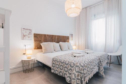 a white bedroom with a large bed and a window at Altair apartment by People Rentals in Bilbao