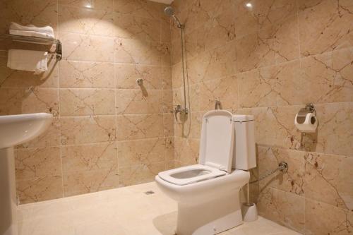 a bathroom with a toilet and a shower and a sink at Borj Al Thahabiah ApartHotel in Taif