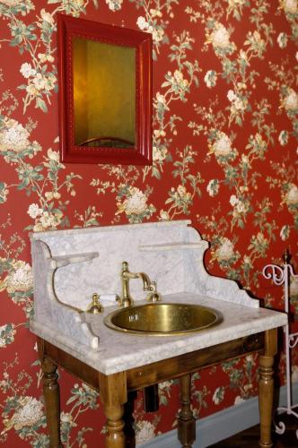 a sink in a bathroom with a red wall at Relais B in Ancona