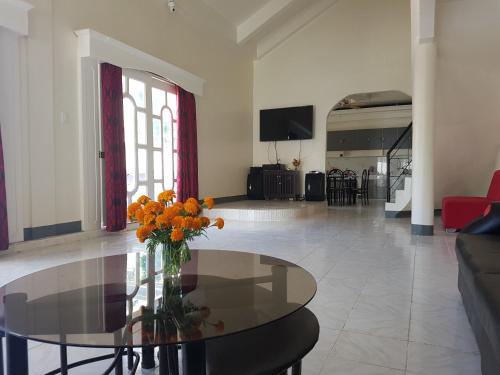 a living room with a glass table with flowers on it at OMG Guesthouse room for 7 in Quinawitnan