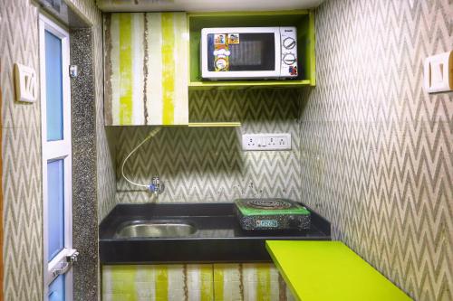 a small bathroom with a sink and a microwave at OSI Apartments Jogeshwari West in Mumbai