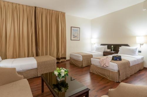 pokój hotelowy z 2 łóżkami i stołem w obiekcie Le Commodore Hotel w Bejrucie