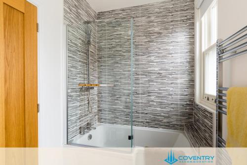 a bathroom with a tub with a glass shower at Hill Cottage Apartments Coleshill Open for NEC weekend visitors - Hosted By Coventry Accommodation in Coleshill