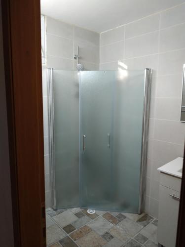 La salle de bains est pourvue d'une douche avec une porte en verre. dans l'établissement lake view, à Tibériade