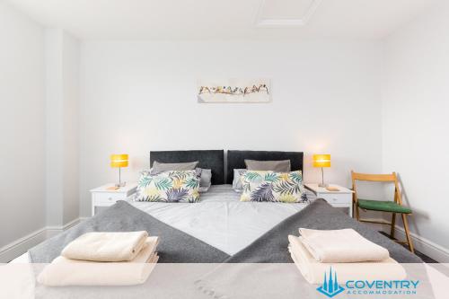 a bedroom with a large bed with pillows on it at Hill Cottage Apartments Coleshill Open for NEC weekend visitors - Hosted By Coventry Accommodation in Coleshill