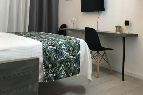a bedroom with a bed with a desk and a chair at stuDio 57 II in Alexandroupoli