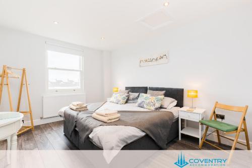 a bedroom with a bed with towels on it at Hill Cottage Apartments Coleshill Open for NEC weekend visitors - Hosted By Coventry Accommodation in Coleshill
