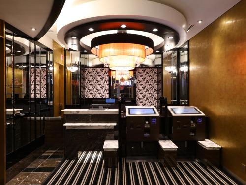 a hotel lobby with sinks and a chandelier at APA Hotel Shinjuku Kabukicho Chuo in Tokyo