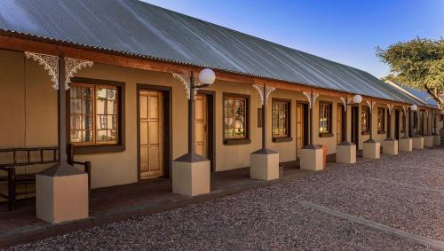 a building with a black roof and a row of windows at Kuruman Hotel in Kuruman