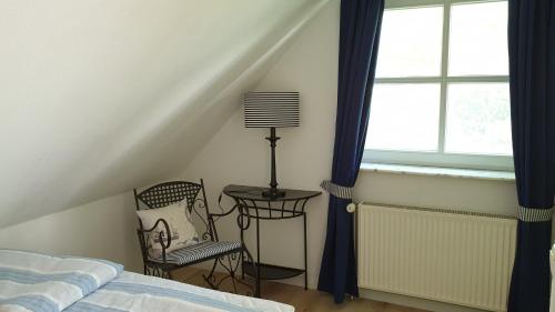 1 dormitorio con 1 cama, 1 silla y 1 ventana en Amber Lodge en Seevetal