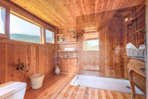 a wooden bathroom with a tub and a window at 3 Oda Kaş in Kas