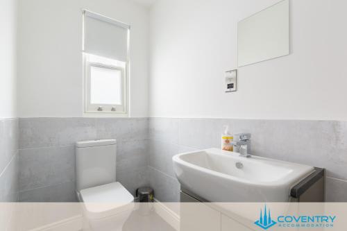 a bathroom with a white toilet and a sink at Hill Cottage Apartments Coleshill Open for NEC weekend visitors - Hosted By Coventry Accommodation in Coleshill