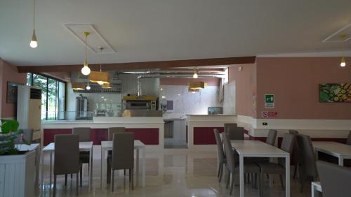 un ristorante con tavoli e sedie e una cucina di Hotel Colombo a Marghera