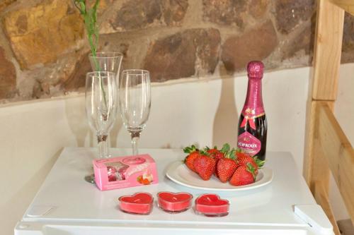 a table with glasses and strawberries and a bottle of wine at Shala Mushe Tented Camp & Camp in Bela-Bela