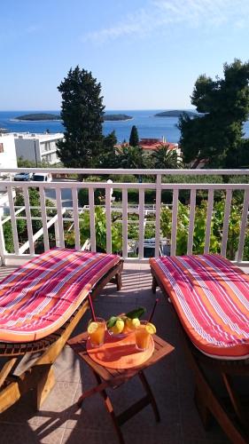 a balcony with two chairs and a tray of fruit at Apartments Mare in Hvar