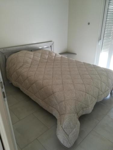 a bed with a blanket on the floor in a room at Aub Ptit Confort in Dienville