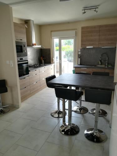 a kitchen with a table and some chairs in it at Aub Ptit Confort in Dienville