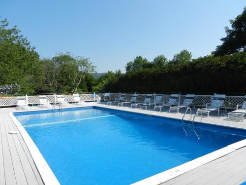 a large blue swimming pool with chairs at Cedar Crest Inn in Camden