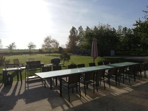 a group of tables and chairs and an umbrella at Gite Bobinou in Lisbourg
