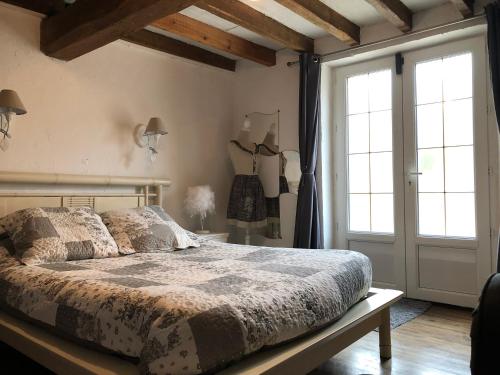 une chambre avec un lit et une grande fenêtre dans l'établissement Maison D Helene, à Villy