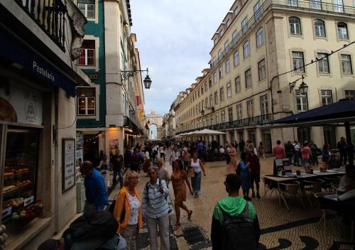 a group of people walking down a street with buildings at Casa René - Charming apartments in Almada