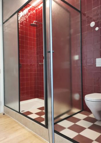 a bathroom with a glass shower with a toilet at Casa René - Charming apartments in Almada