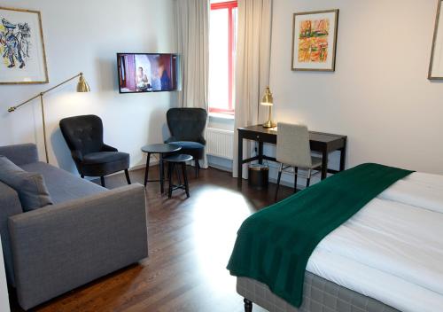 a bedroom with a bed and a desk and chairs at Rasta Grums in Grums