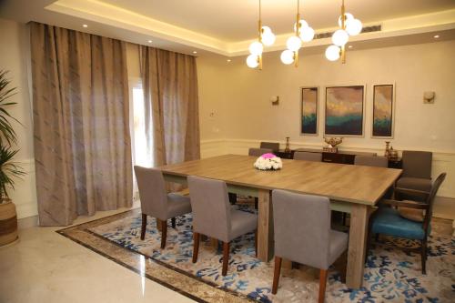 a dining room with a wooden table and chairs at Tolip North Coast Hotel in El Alamein
