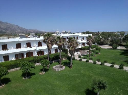 - une vue aérienne sur un grand bâtiment blanc avec des palmiers dans l'établissement Studios Stavris, à Frangokastello
