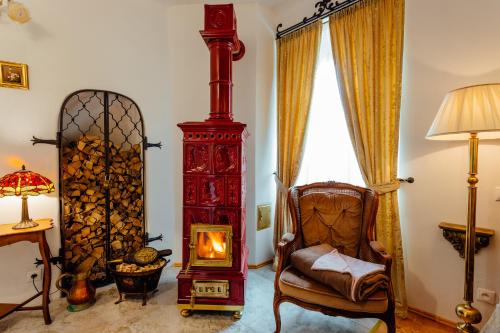 a living room with a wood stove and a chair at Strieborný dvor in Banská Štiavnica