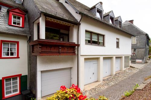 Casa blanca con 4 puertas de garaje y ventanas rojas en Ferienhaus Mühlenberg en Monschau