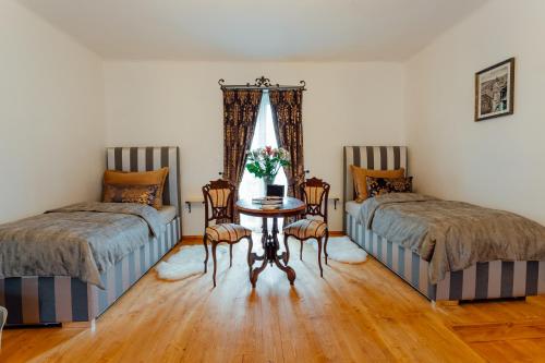 a room with two beds and a table with chairs at Strieborný dvor in Banská Štiavnica