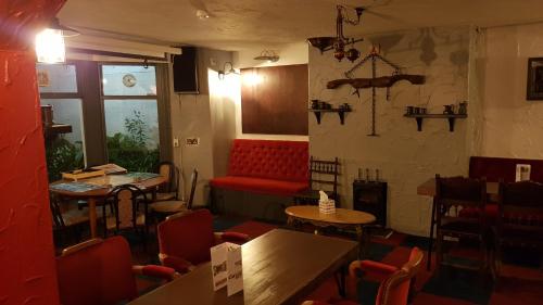 a restaurant with a red couch and tables and chairs at Leofric Legends in Blackpool