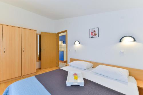 - une chambre avec 2 lits et une table dans l'établissement Apartments Summer Dream, à Privlaka