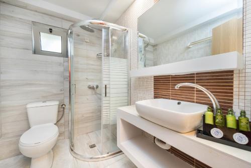 a bathroom with a toilet and a sink and a shower at Crystal Beach Hotel in Kalamaki