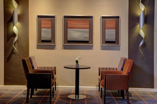 a table and chairs in a room with windows at Best Western Aberavon Beach Hotel in Port Talbot