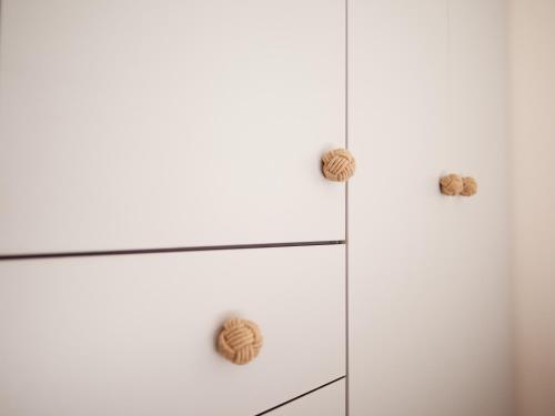 a white dresser with two knobs on it at Alexis Studios in Finikounta