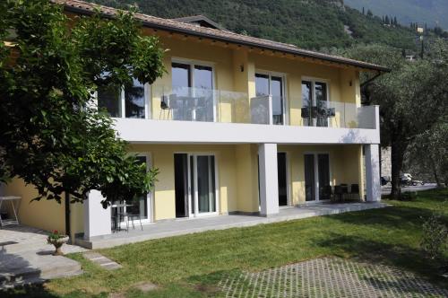 une grande maison jaune avec une cour dans l'établissement Casa Guarnati Lake View Apartments, à Malcesine