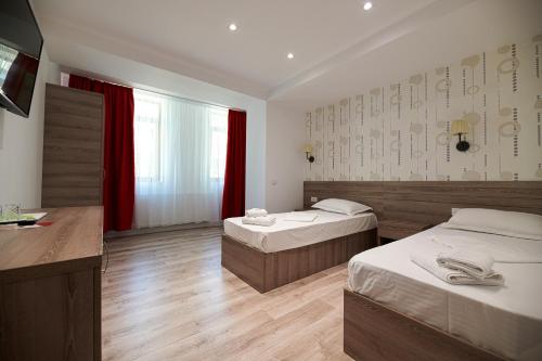
a bedroom with a bed and a dresser at Hotel Liad City Center in Bucharest
