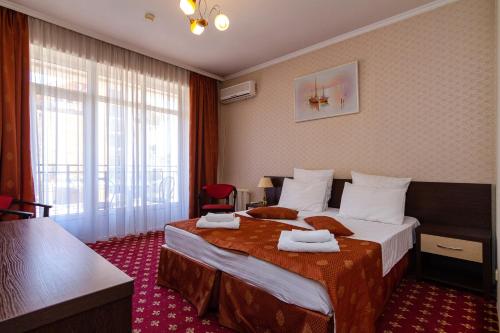 Una habitación de hotel con una cama con toallas. en Sharm Hotel en Adler