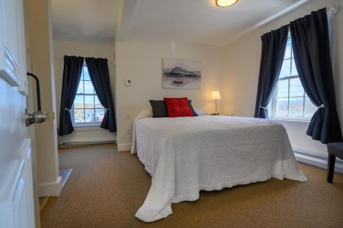 巴德克的住宿－電報之家汽車旅館，卧室配有白色的床和2扇窗户。