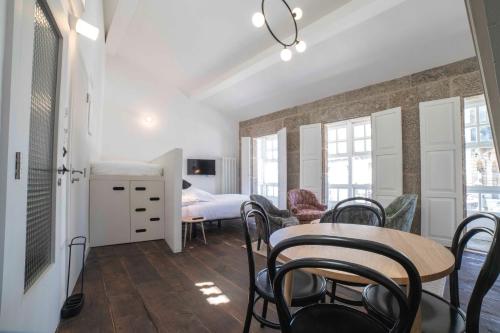 een kamer met een tafel en stoelen en een slaapkamer bij Inferniño Apartments in Santiago de Compostela