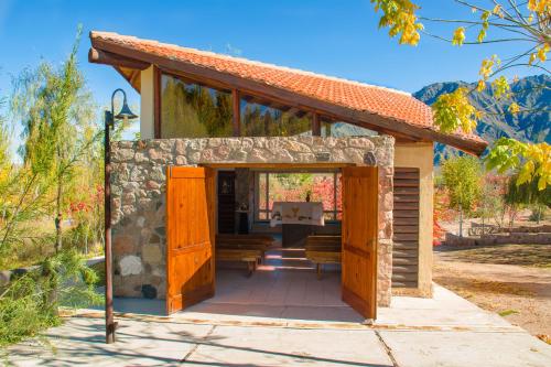 a small building with a porch with a stone wall at Aguilas de Piedra in Cacheuta