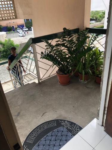 a man walking down the stairs of a building with plants at Cityscape at Chelsea Manor / New Kingston Studio! in Kingston
