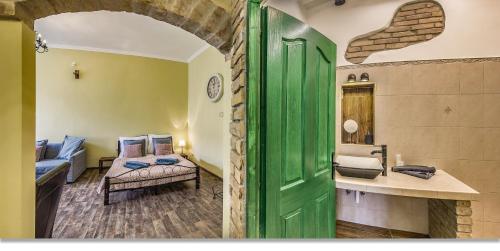 a living room with a green door and a bedroom at Wine Cellar Boutique Apartment in Budapest